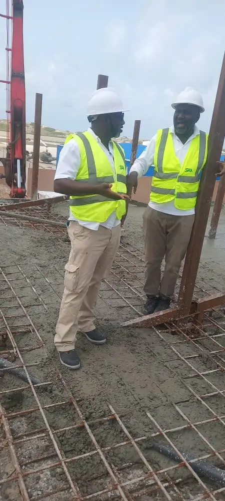 Two HSEQ professionals supervising concrete casting on a reinforced construction slab