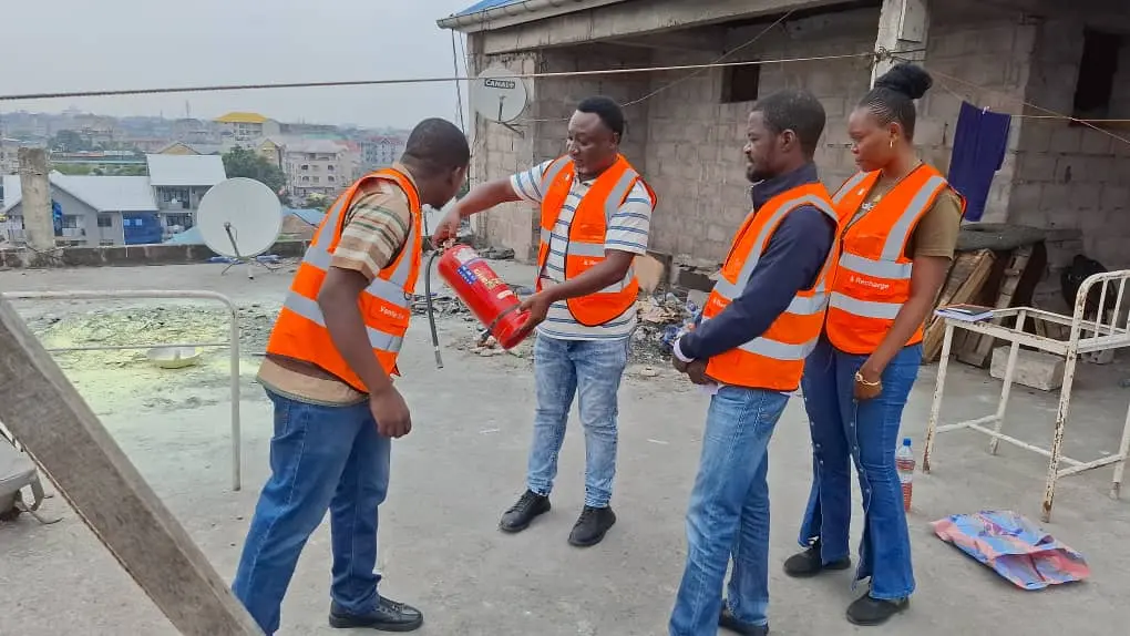 Workers receiving hands-on portable fire extinguisher instruction in the Democratic Republic of the Congo